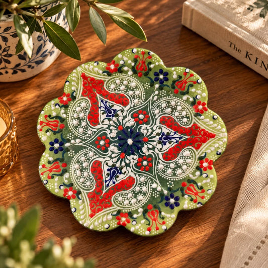 Apoya fuente de forma floral en verde con motivos paisley rojos, flores azul marino y puntos blancos