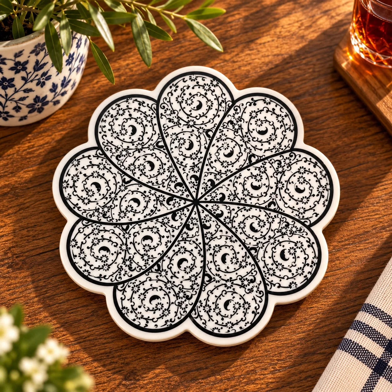 Apoya fuente blanco y negro con pétalos en espiral y enredadera floral minuciosa