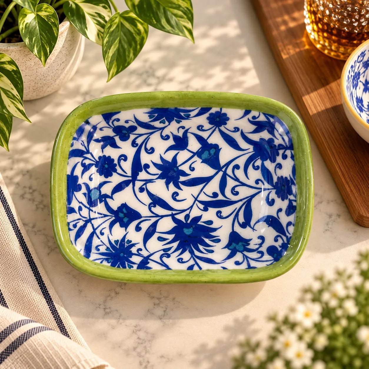 Plato rectangular de cerámica con borde verde, flores azules densas sobre fondo blanco