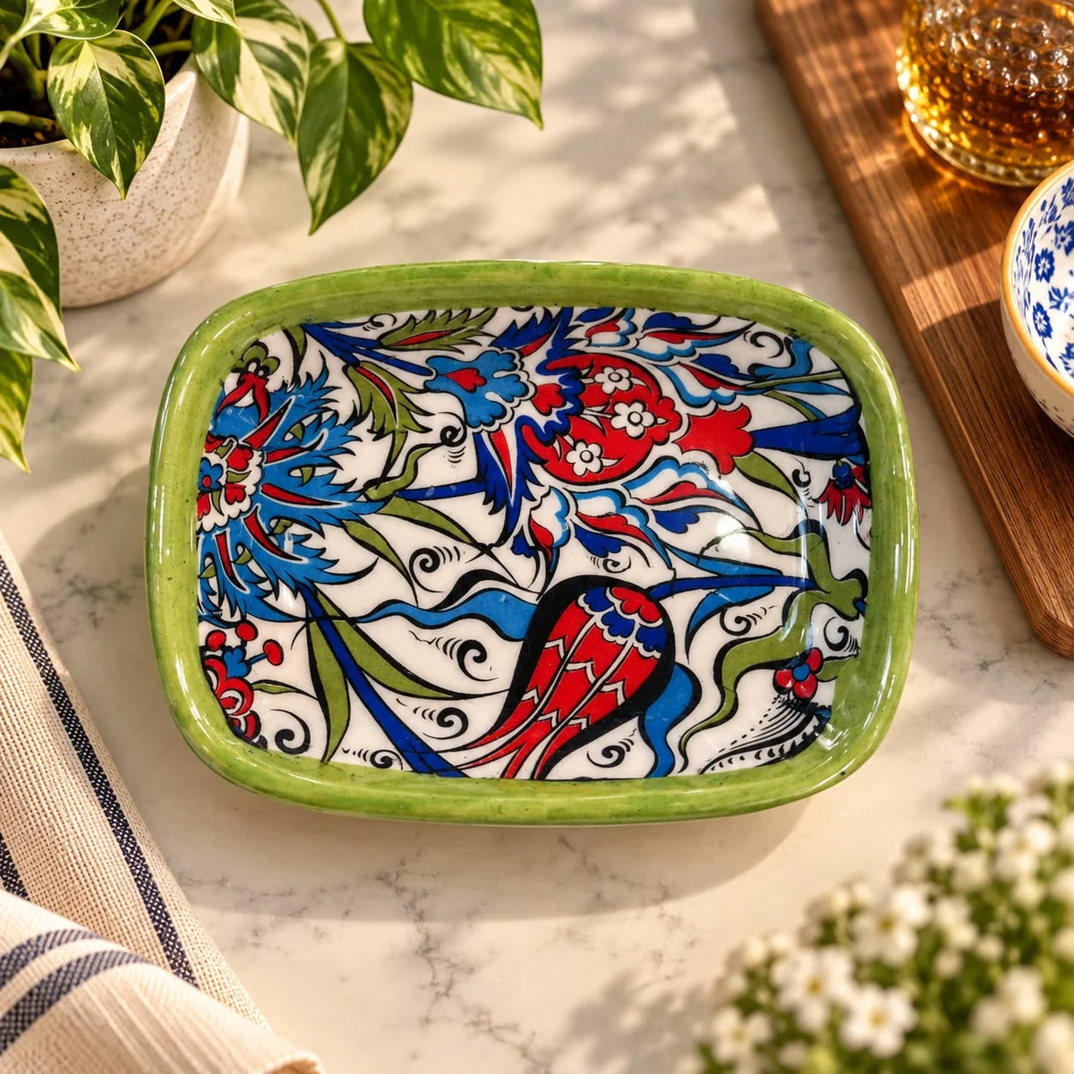 Bandeja blanca con motivo floral otomano en rojo, azul y verde, contorno negro y borde verde