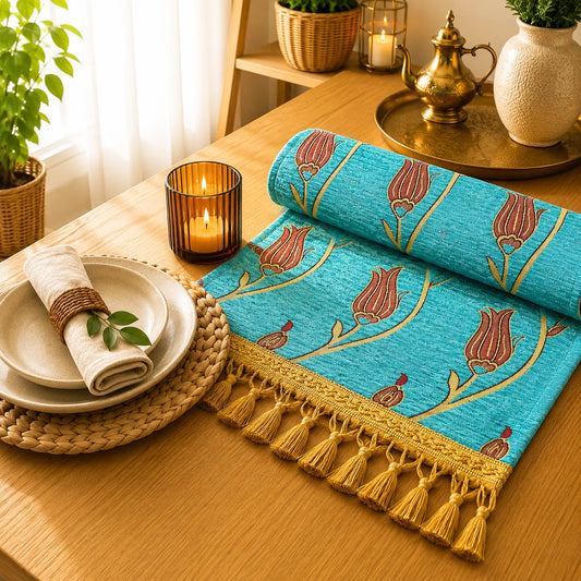 Camino de mesa turquesa con tulipanes granate de tallos dorados y pequeños capullos rojos, bordado en relieve, con borlas doradas.